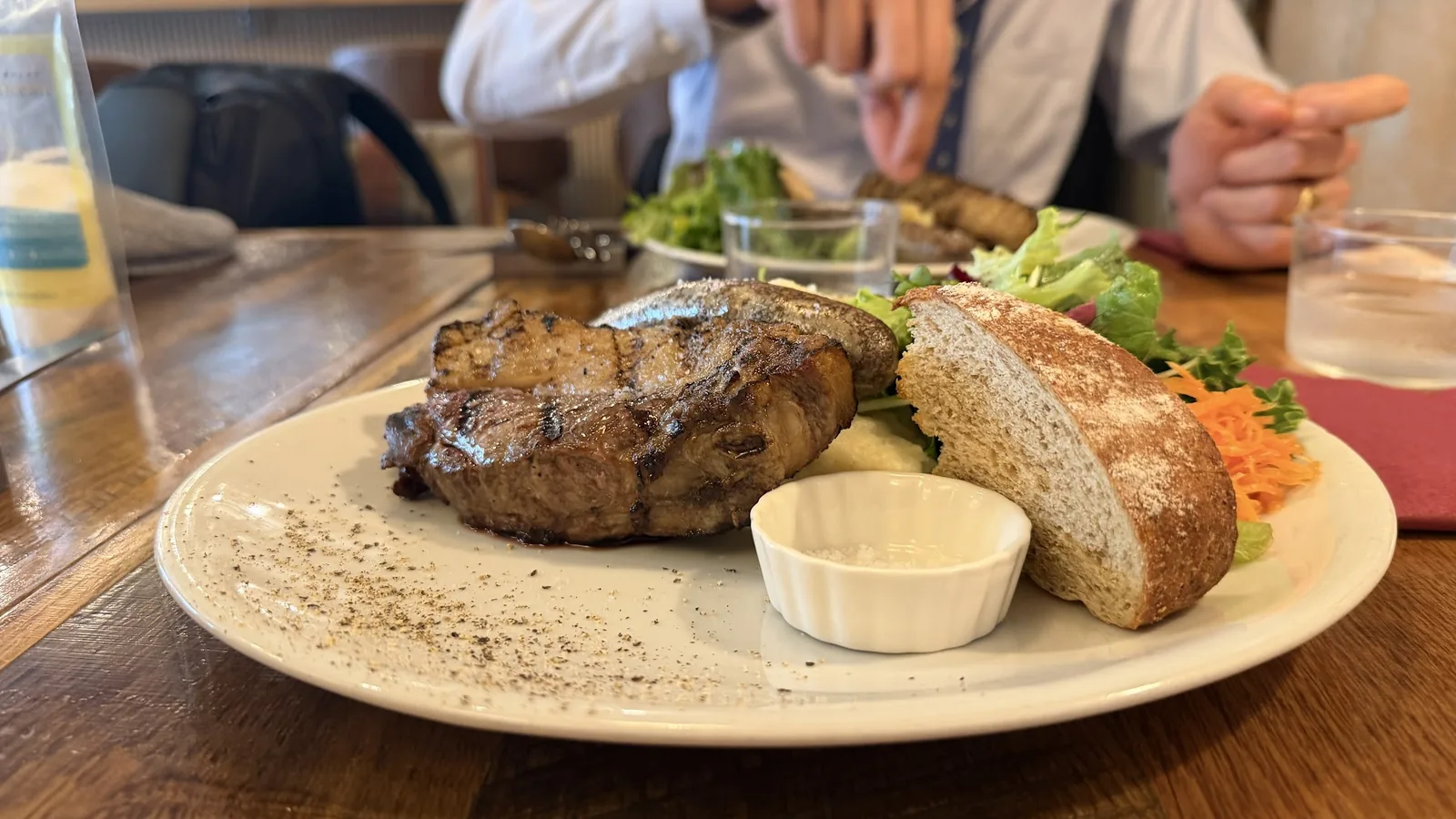 サラダとパンを添えたジビエステーキの皿。